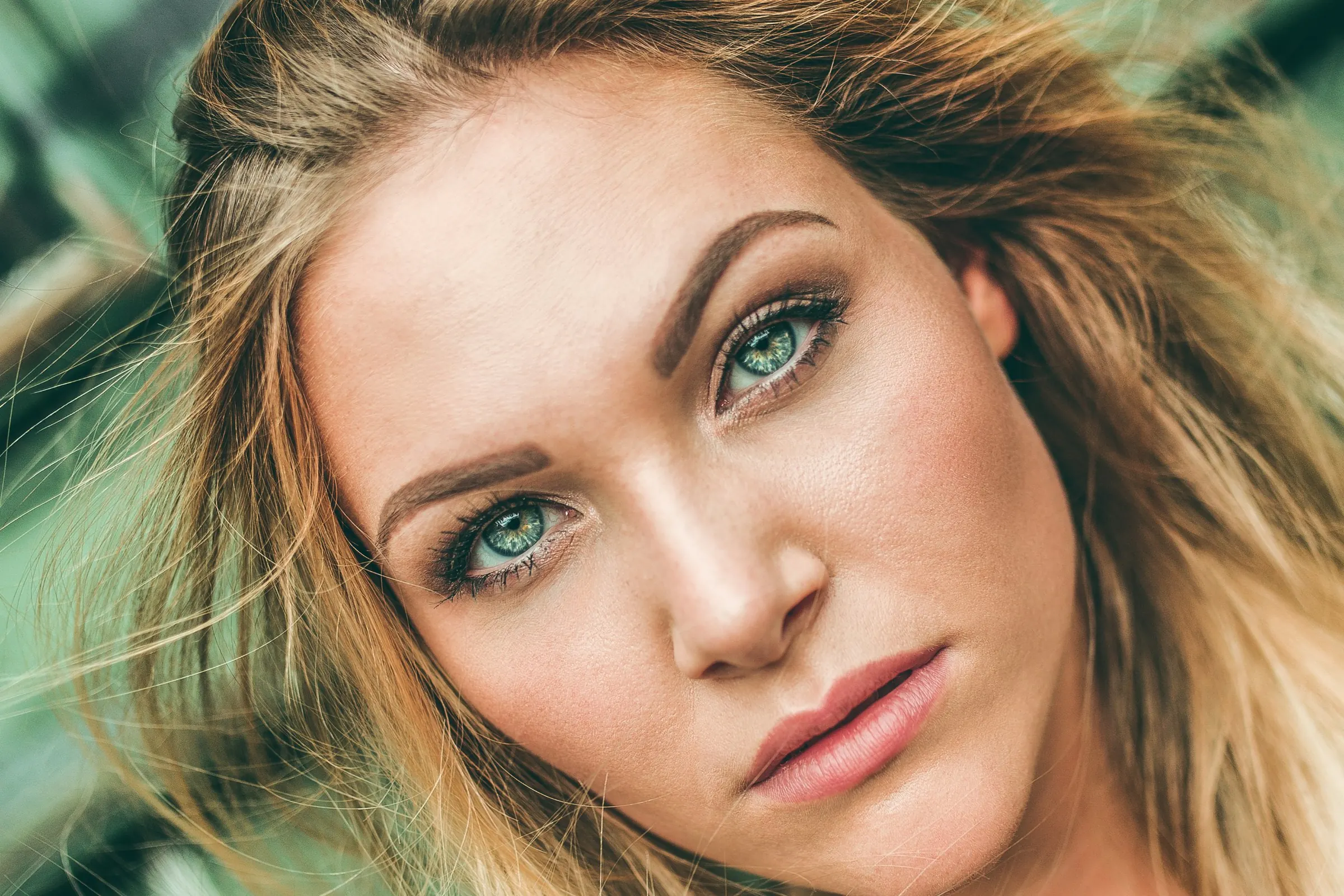 Beauty-Porträt einer blonden Frau mit grünen Augen in Nahaufnahme