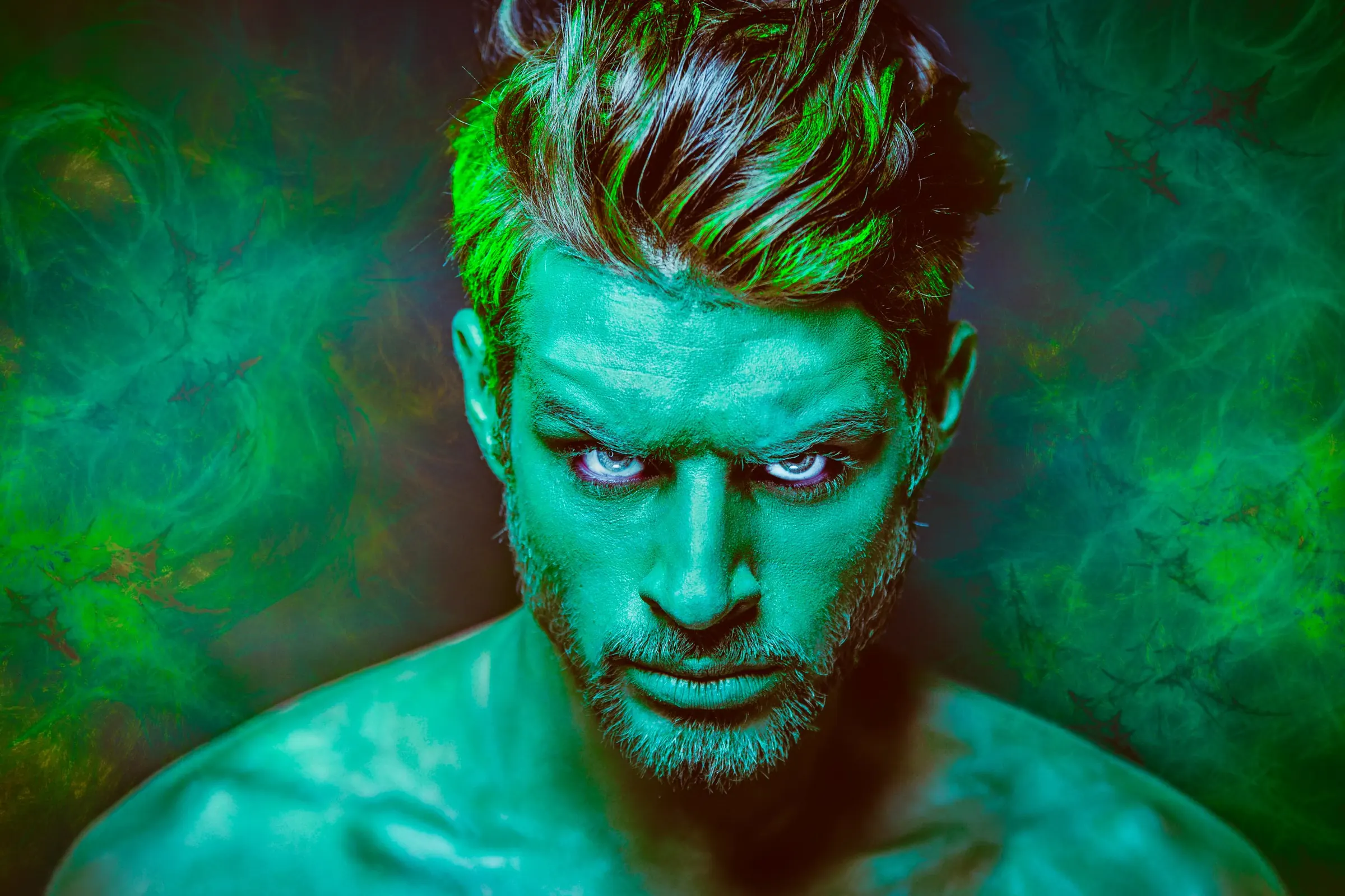Fine-Art-Porträt eines Mannes mit grünem Bodypainting und hellen Augen