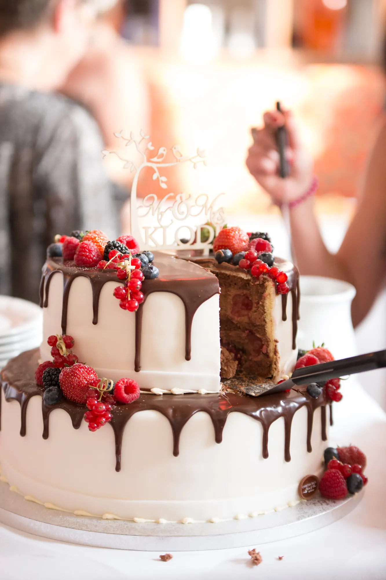 Anschnitt der Hochzeitstorte mit Beeren und Schokolade