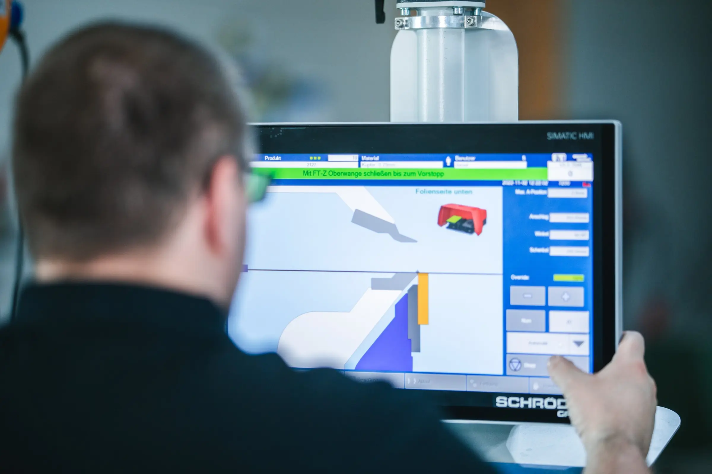 Industriefotografie: Mitarbeiter bedient das Touch-Display einer Maschine in der Fertigung