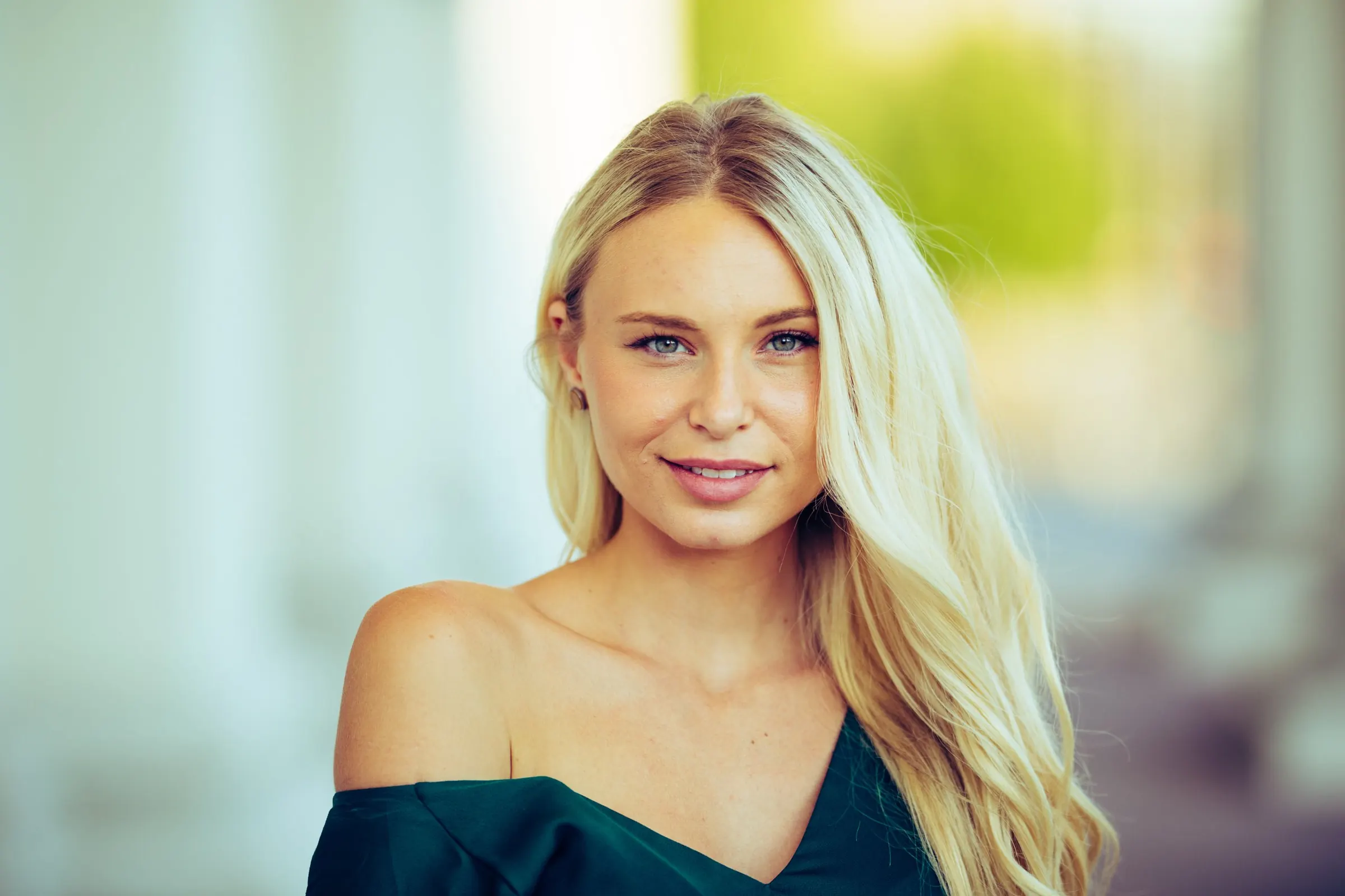Natürliches Porträt einer lächelnden blonden Frau im Freien