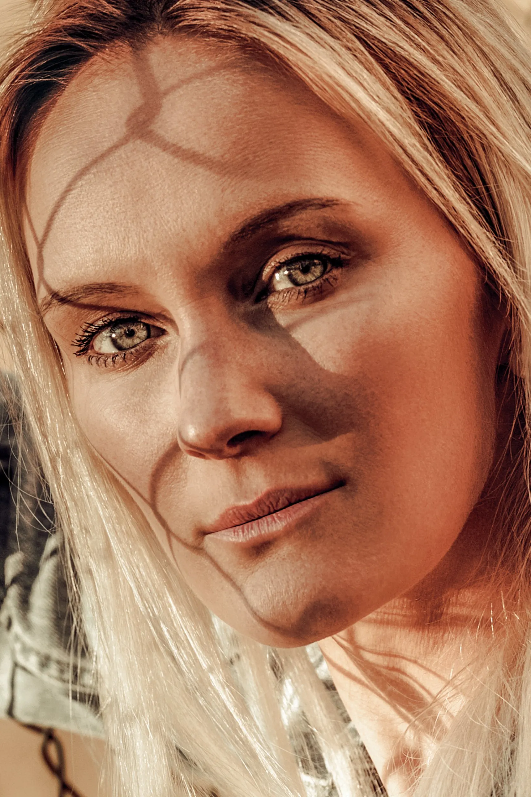 Porträt einer blonden Frau mit einem Schattenmuster aus Licht auf dem Gesicht