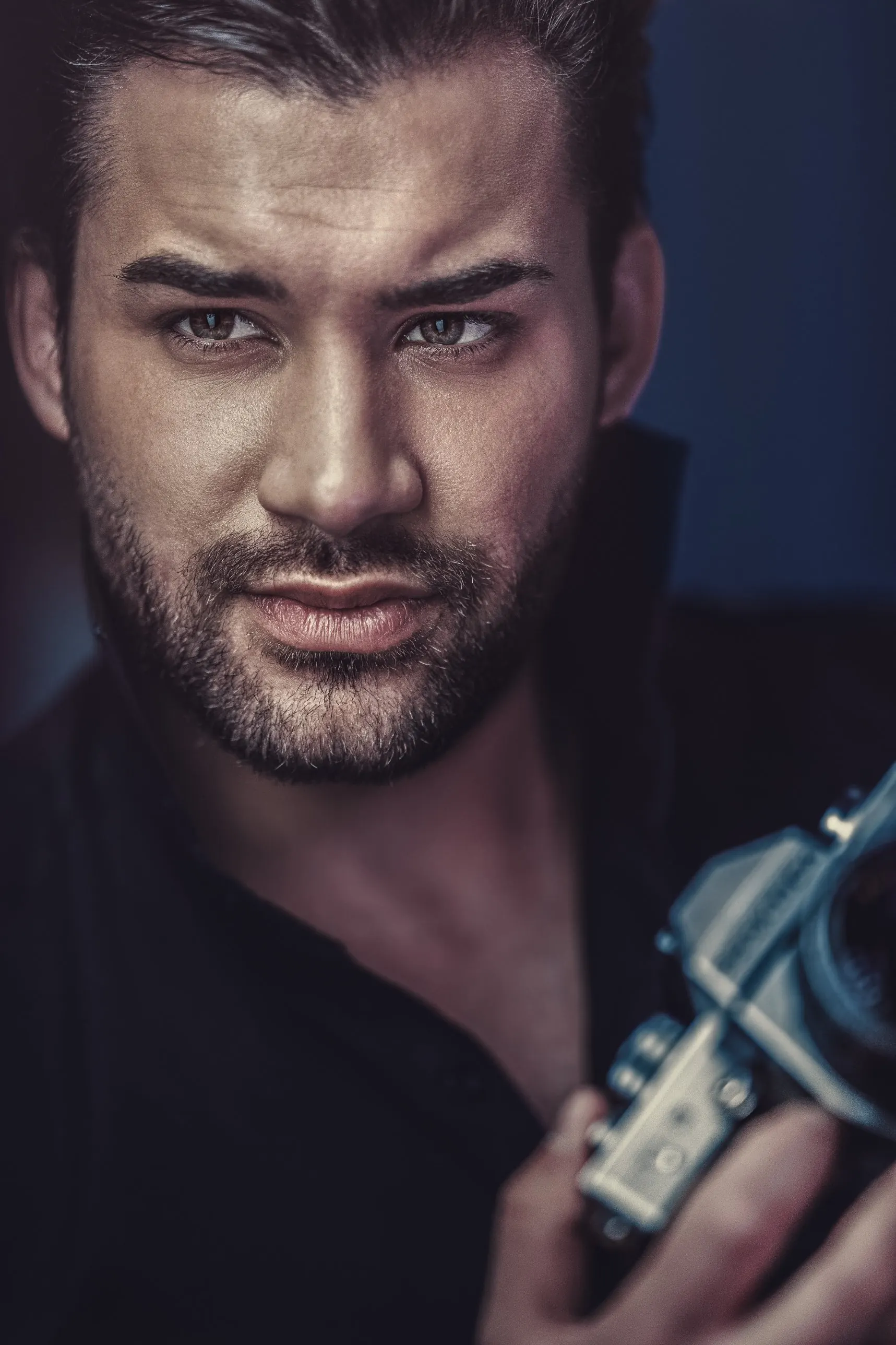 Porträtfotografie: Mann mit Kamera, dunkler Hintergrund