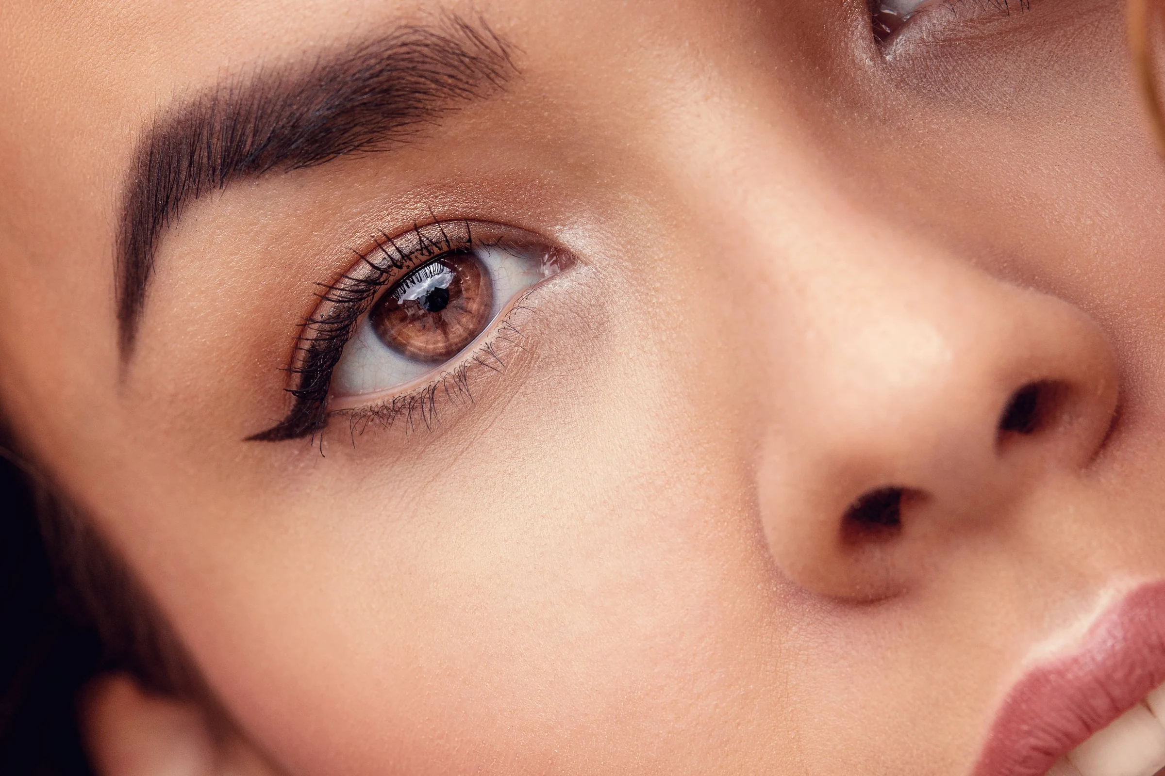 Detail: Auge, Nase und Lippen im Streiflicht