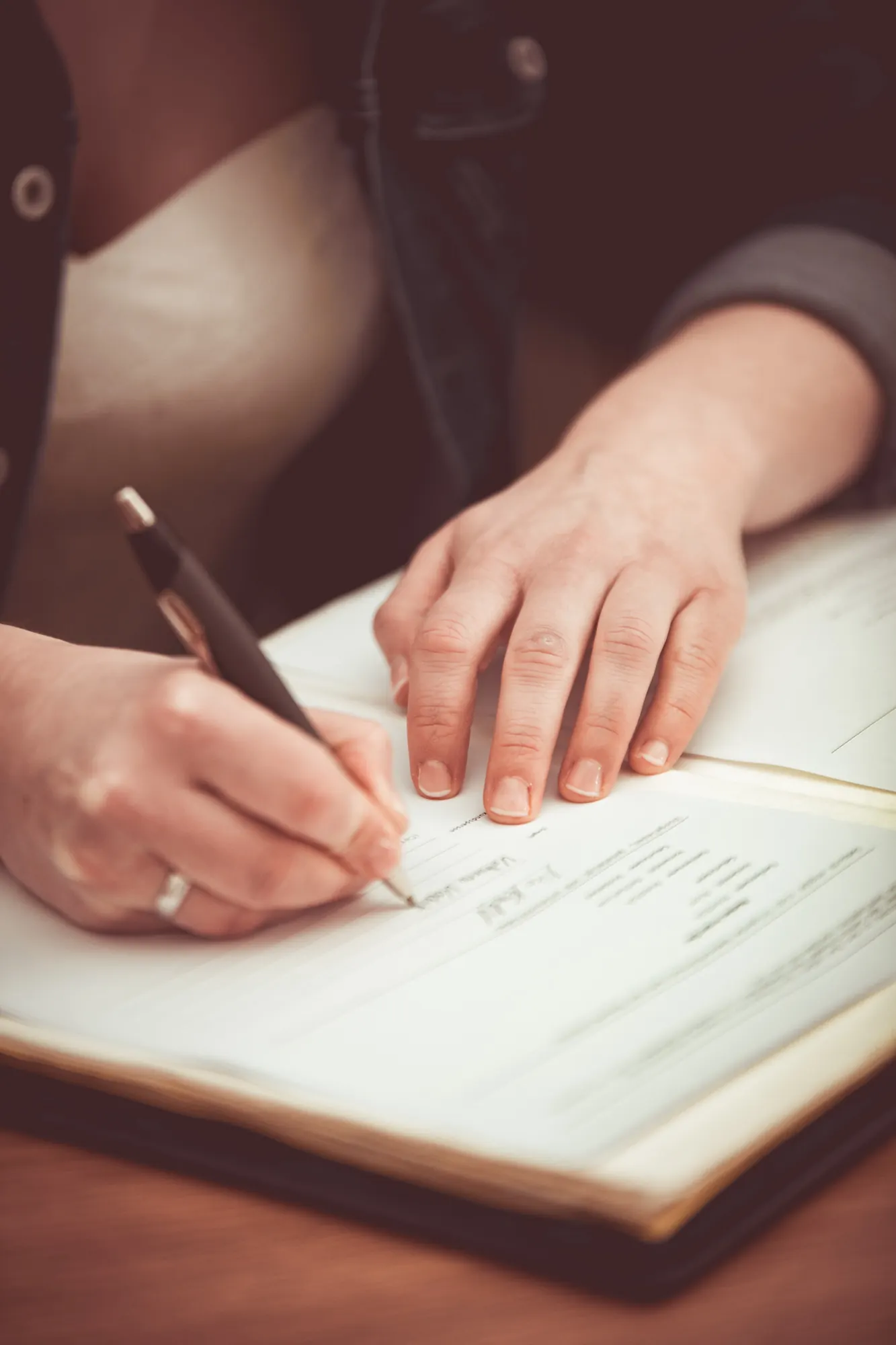 Unterschrift im Standesamt, Hand mit Ehering