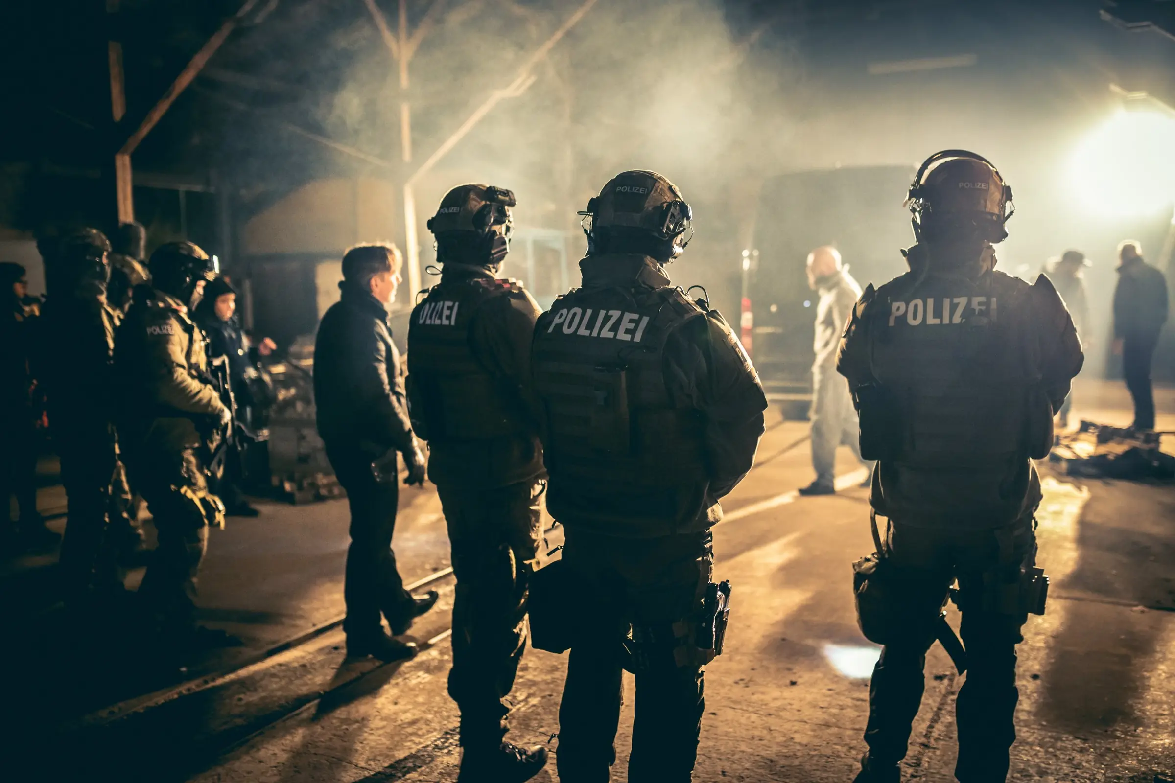 Standfotografie am Filmset: Darsteller als Polizei-Einsatzkräfte im Gegenlicht und Nebel