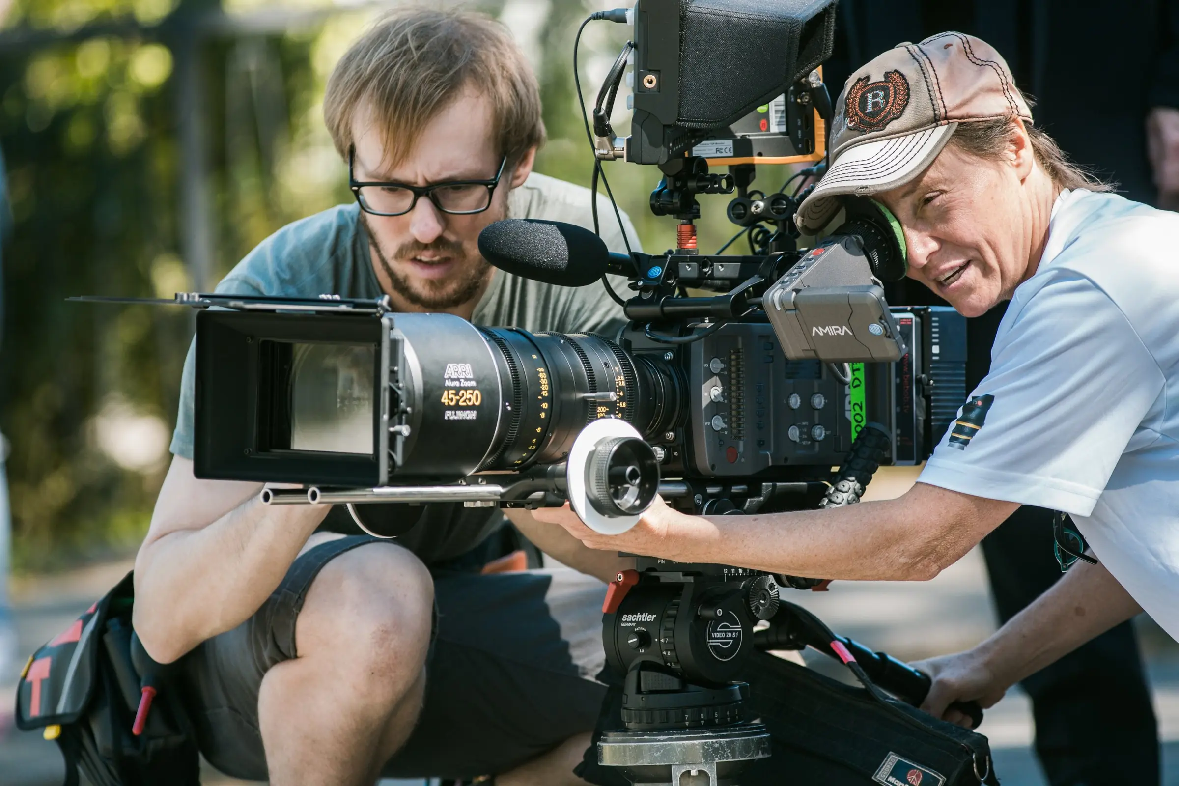 Behind the Scenes: Kamerateam richtet eine Filmkamera mit Zoomobjektiv auf dem Stativ ein